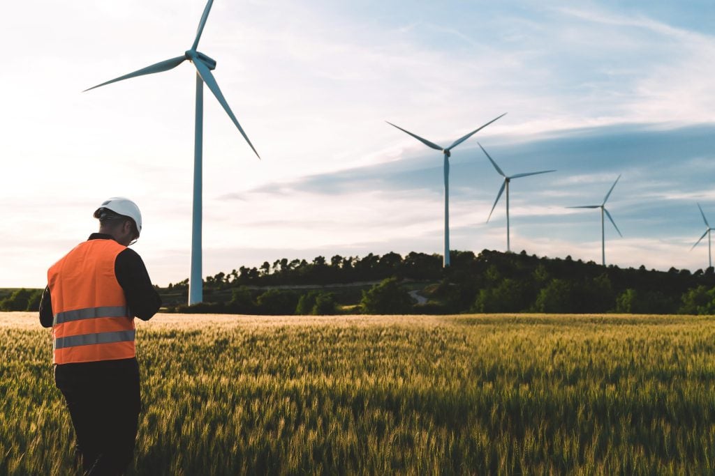 Arbeiter, der unter Windkraftanlage steht