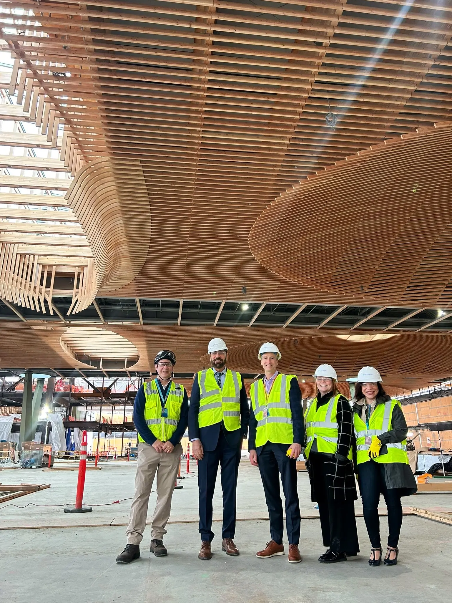 Minister Jagrup Brar ist mit mehreren Kollegen in einem neuen Abschnitt des Flughafens von Portland, OR, abgebildet, der in Massivholzbauweise errichtet wurde